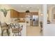 Well-lit kitchen featuring tile floors, wooden cabinets, stainless steel appliances, and a breakfast bar at 9361 Carnaby Dr, Venice, FL 34293