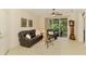Inviting living room featuring a comfortable leather sofa, chair, ceiling fan, and access to the screened-in patio at 9361 Carnaby Dr, Venice, FL 34293