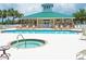 Pool and spa surrounded by lounge chairs, palm trees, and a clubhouse at 9361 Carnaby Dr, Venice, FL 34293