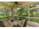 Comfortable screened porch with patio furniture, providing a relaxing view of the lush backyard at 9361 Carnaby Dr, Venice, FL 34293
