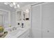 Bathroom with a toilet, sink, mirror, white cabinets, and decorative items at 950 Tarpon Center Dr # 305, Venice, FL 34285