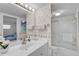 Bathroom with a toilet, sliding glass door shower, mirror, sink, and lighthouse wallpaper at 950 Tarpon Center Dr # 305, Venice, FL 34285