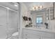 Bathroom with a toilet, glass door shower, mirror, sink, and white cabinets at 950 Tarpon Center Dr # 305, Venice, FL 34285