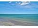 Serene beach scene featuring clear turquoise water and gentle waves washing ashore at 950 Tarpon Center Dr # 305, Venice, FL 34285