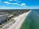 Aerial view of a stunning beach with white sand and clear turquoise water on a sunny day at 950 Tarpon Center Dr # 305, Venice, FL 34285