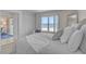 Bright bedroom with a full bed, wicker headboard, large window, and ocean view at 950 Tarpon Center Dr # 305, Venice, FL 34285