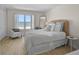 Bright bedroom with a full bed, wicker headboard, chair, and ocean view at 950 Tarpon Center Dr # 305, Venice, FL 34285