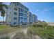 Exterior shot of condo building with blue windows and lush landscaping at 950 Tarpon Center Dr # 305, Venice, FL 34285