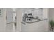 Modern kitchen featuring white cabinetry, stainless steel appliances, and granite countertops, seamlessly flowing from the entryway at 950 Tarpon Center Dr # 305, Venice, FL 34285