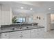 Open kitchen with granite countertops and stainless steel sink overlooking the living area and stunning ocean views at 950 Tarpon Center Dr # 305, Venice, FL 34285