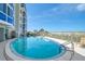 Beautiful blue pool by the building with clear water, palm trees, and ocean view at 950 Tarpon Center Dr # 305, Venice, FL 34285