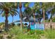 Entrance to Venice Beach with tall palm trees and lush, green vegetation at 950 Tarpon Center Dr # 305, Venice, FL 34285