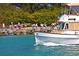 Scenic waterfront view with boat cruising by and people relaxing by the water at 950 Tarpon Center Dr # 305, Venice, FL 34285