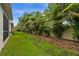 A lush backyard featuring a privacy fence surrounded by beautiful trees and manicured landscaping at 121 Colebrook Ct, Venice, FL 34292