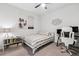 Cozy bedroom with a striped bedspread, decor art, a ceiling fan, and a compact work station at 121 Colebrook Ct, Venice, FL 34292