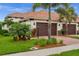 Charming home exterior with brick driveway and lush landscaping featuring mature palm trees at 121 Colebrook Ct, Venice, FL 34292