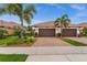 Charming single-story home with brown garage doors and beautiful, mature landscaping at 121 Colebrook Ct, Venice, FL 34292