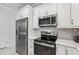 Modern kitchen featuring stainless steel appliances and white cabinets at 121 Colebrook Ct, Venice, FL 34292