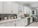 Bright kitchen featuring white cabinetry, stainless steel appliances, and quartz countertops at 121 Colebrook Ct, Venice, FL 34292