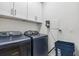 Functional laundry room with modern washer and dryer units and ample storage space at 121 Colebrook Ct, Venice, FL 34292