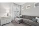 Cozy living room featuring a gray sectional sofa, window shutters, and stylish decor at 121 Colebrook Ct, Venice, FL 34292