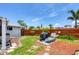 Landscaped backyard featuring a charming patio area, lush lawn, wooden fence and mature trees at 1222 Pinebrook Way, Venice, FL 34285