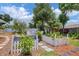 Landscaped backyard with mature trees, including a charming garden with a white picket fence at 1222 Pinebrook Way, Venice, FL 34285
