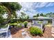 Backyard featuring lush landscaping, charming patio area, spa with privacy fence, and mature trees at 1222 Pinebrook Way, Venice, FL 34285