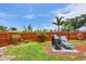 Landscaped backyard featuring a charming patio area, lush lawn, wooden fence and mature trees at 1222 Pinebrook Way, Venice, FL 34285