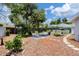 Inviting backyard featuring mature trees, patio seating, and lush landscaping, perfect for outdoor relaxation at 1222 Pinebrook Way, Venice, FL 34285