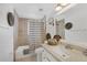 Well-maintained bathroom with tiled shower/tub combination, vanity, and ample lighting at 1222 Pinebrook Way, Venice, FL 34285