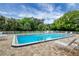 Large community pool with brick patio, surrounded by lush landscaping and plenty of lounge chairs at 1222 Pinebrook Way, Venice, FL 34285