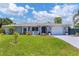 Charming one-story home with well-manicured lawn and landscaping and front porch seating at 1222 Pinebrook Way, Venice, FL 34285