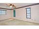 Bedroom with a ceiling fan, carpet, and windows adorned with vertical blinds at 1290 Leeward Rd, Venice, FL 34293
