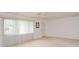 Bright living room with large window, neutral walls, plush carpeting, and a ceiling fan at 1290 Leeward Rd, Venice, FL 34293