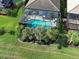 Aerial view of a home featuring a screened-in pool, lush landscaping, and a well-maintained lawn at 13862 Miranese St, Venice, FL 34293