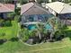 Aerial view of a home featuring a screened-in pool, lush landscaping, and a well-maintained lawn at 13862 Miranese St, Venice, FL 34293