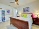 Bright bedroom featuring ceiling fan, wood bed frame, bedside table, and colorful accessories at 13862 Miranese St, Venice, FL 34293