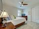 Nicely staged bedroom boasts ceiling fan, shuttered window, wood bed frame, and attractive lamps at 13862 Miranese St, Venice, FL 34293