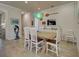 Inviting dining room with a wooden table, white chairs, unique light fixture, and stylish decor at 13862 Miranese St, Venice, FL 34293