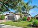 Charming home featuring a well-manicured lawn, mature landscaping, and a paved driveway leading to a two-car garage at 13862 Miranese St, Venice, FL 34293