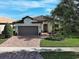 Charming single-story home featuring a brick driveway, two-car garage, and well-manicured landscaping at 13862 Miranese St, Venice, FL 34293