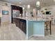 Modern kitchen with island seating, stainless steel appliances, and open floor plan at 13862 Miranese St, Venice, FL 34293