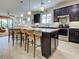 Bright kitchen featuring dark wood cabinets, a center island with bar stool seating, and pendant lighting at 13862 Miranese St, Venice, FL 34293