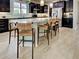 Spacious kitchen with dark wood cabinets, granite countertops, stainless steel appliances, and a large center island at 13862 Miranese St, Venice, FL 34293