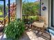 Cozy screened lanai with brick flooring, potted plants, comfortable chair, and view of lush greenery at 13862 Miranese St, Venice, FL 34293