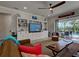 Cozy living room features a large built-in shelving unit, wood ceiling fan, and access to the pool at 13862 Miranese St, Venice, FL 34293