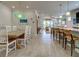 Open-concept living space with breakfast bar, dining table, and view of the living room and pool at 13862 Miranese St, Venice, FL 34293