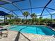 Inviting screened-in pool with patio furniture, grill, and picturesque views of the lake at 13862 Miranese St, Venice, FL 34293
