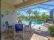 Screened-in pool area with patio furniture, grill, and views of surrounding palm trees and lake at 13862 Miranese St, Venice, FL 34293